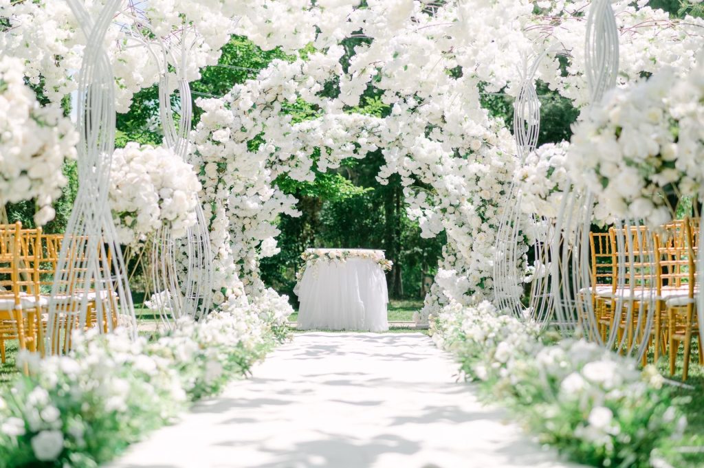 Allée de cérémonie de mariage couverte de fleurs blanches