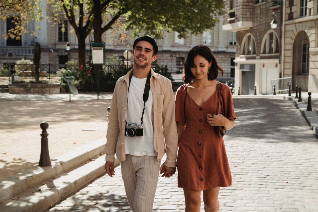 Couple qui marche main dans la main dans une rue pavée de Paris