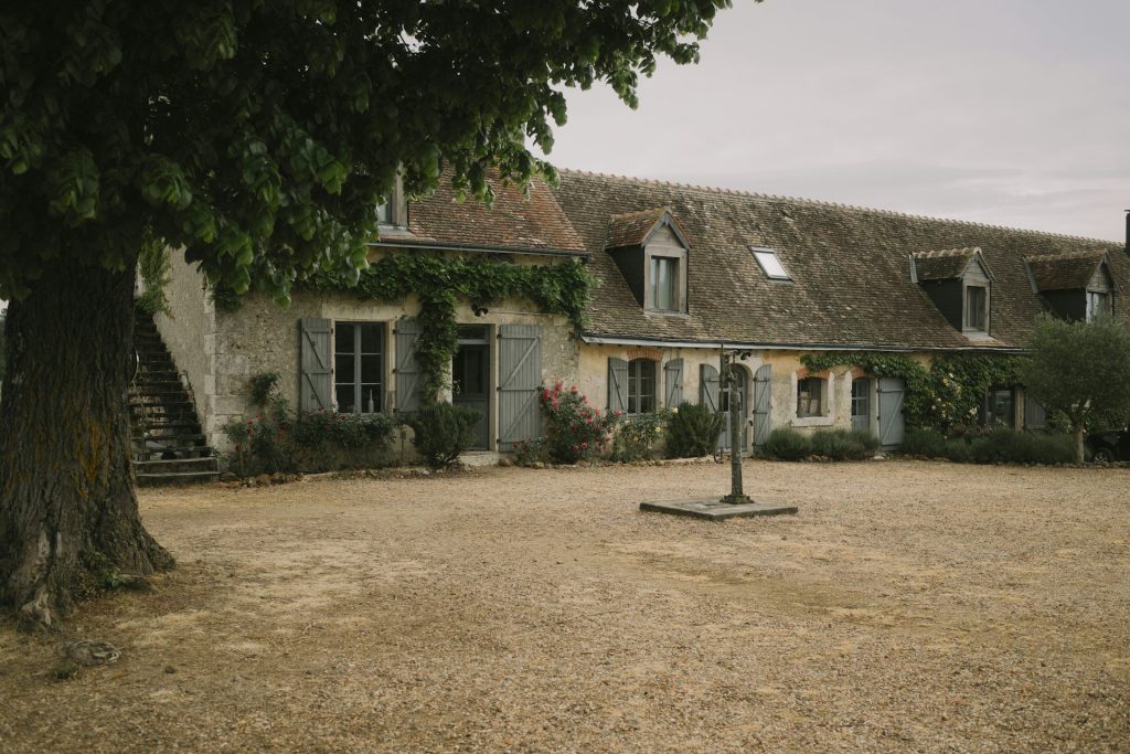 Longère en pierre au milieu de la campagne, typique d’un gîte rural français