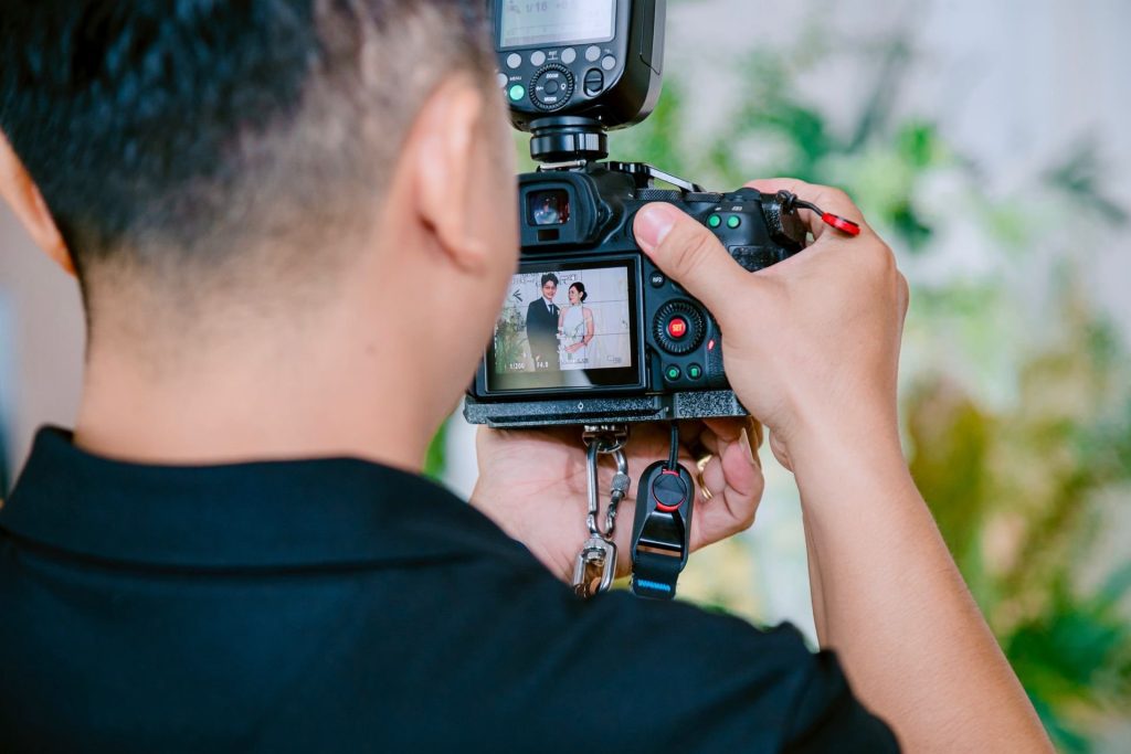 Photographe de mariage cadrant les mariés sur l’écran de son appareil