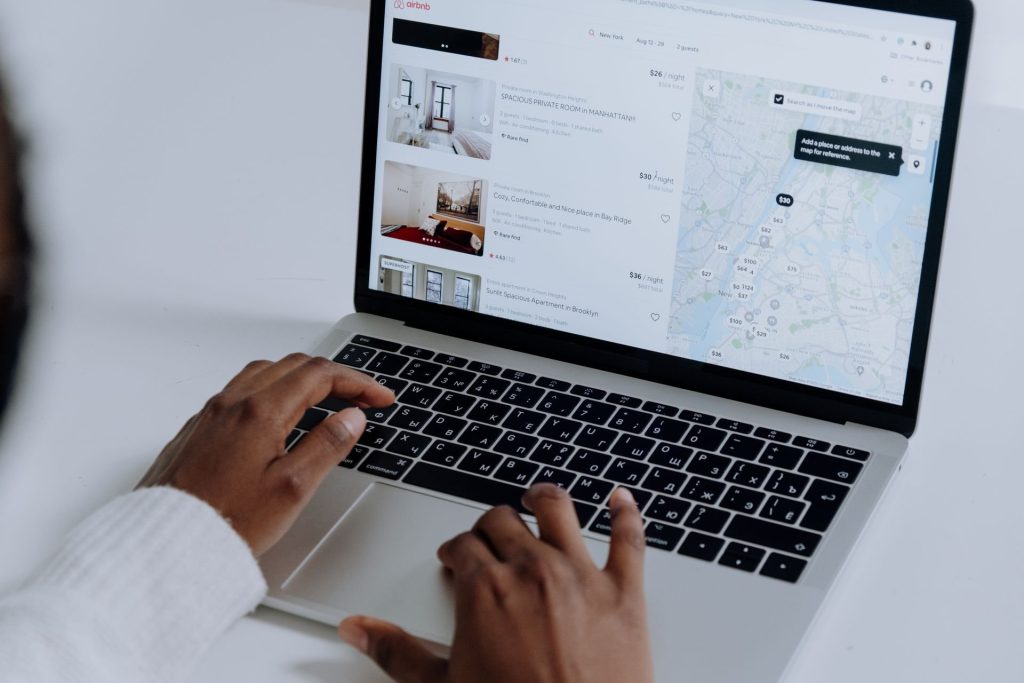 Mains sur un ordinateur portable affichant un site de réservation de logement