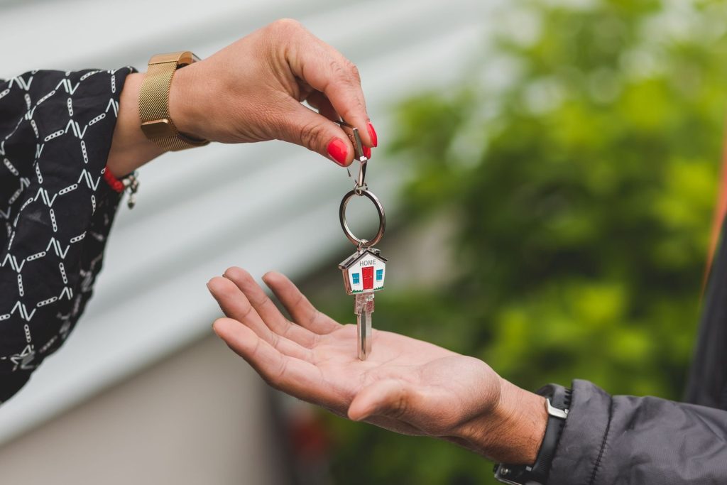 Remise des clés d’une maison avec porte-clés en forme de maison