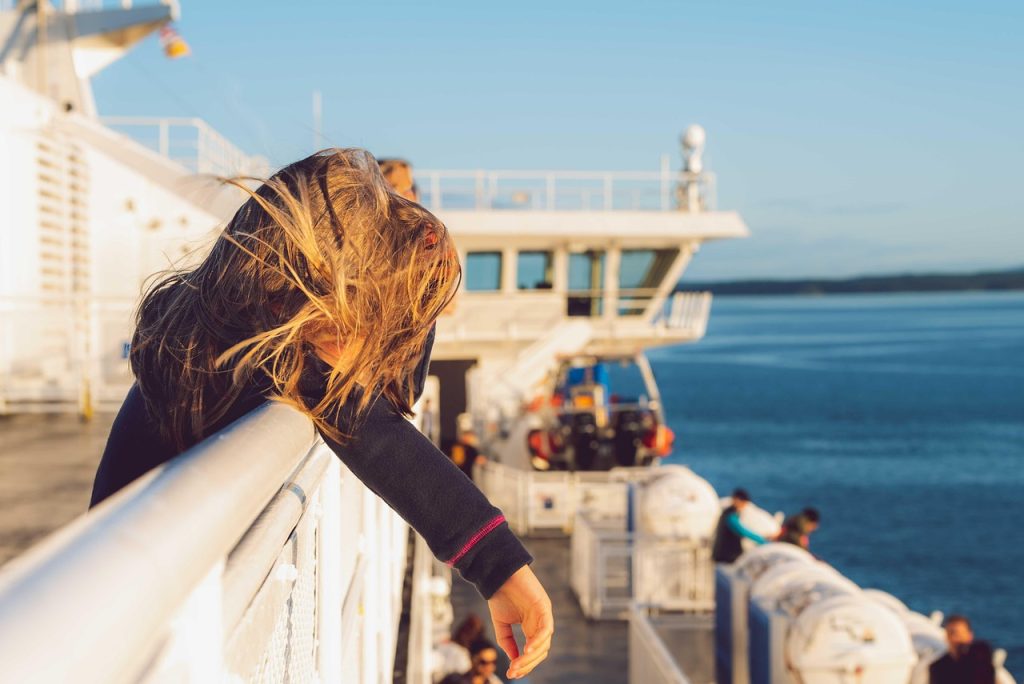 Passagère accoudée au pont d’un ferry en mer